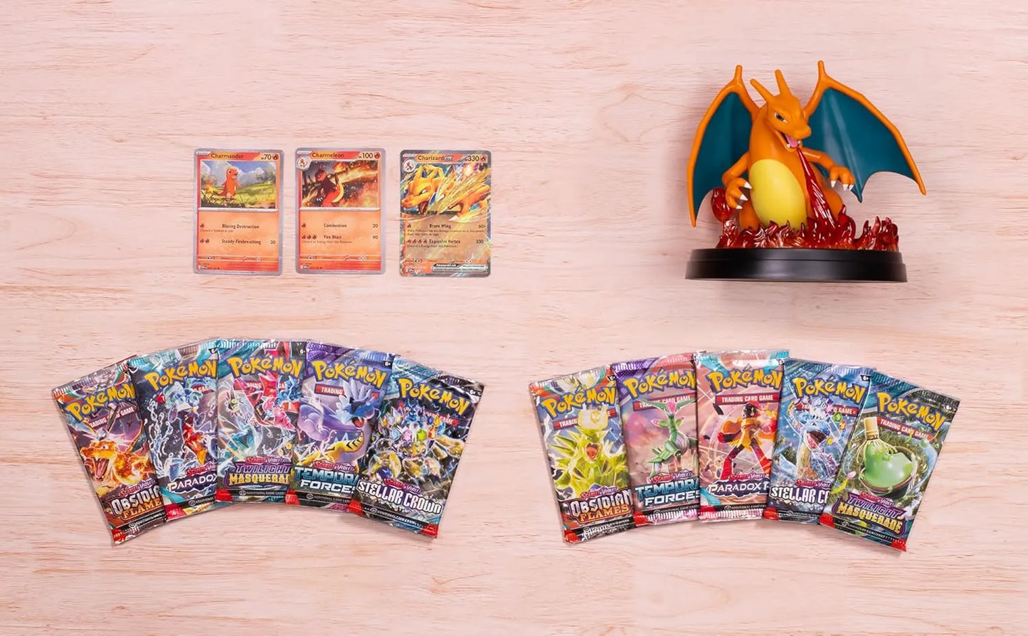 Contenido desplegado: sobres mixtos, figura de Charizard y promos sobre madera