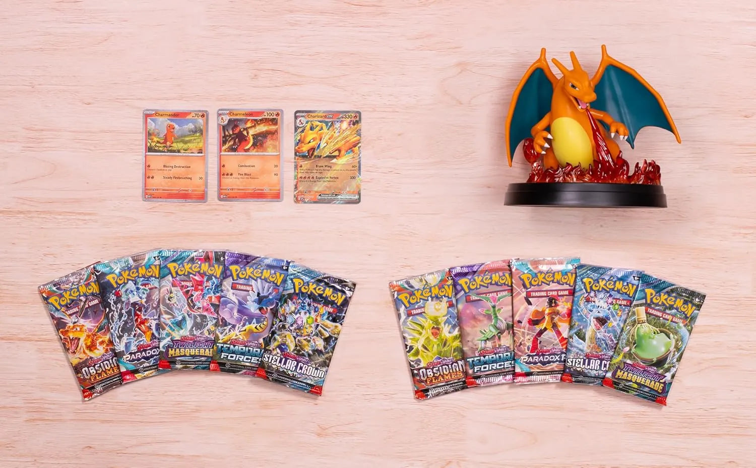 Contenido desplegado: sobres mixtos, figura de Charizard y promos sobre madera